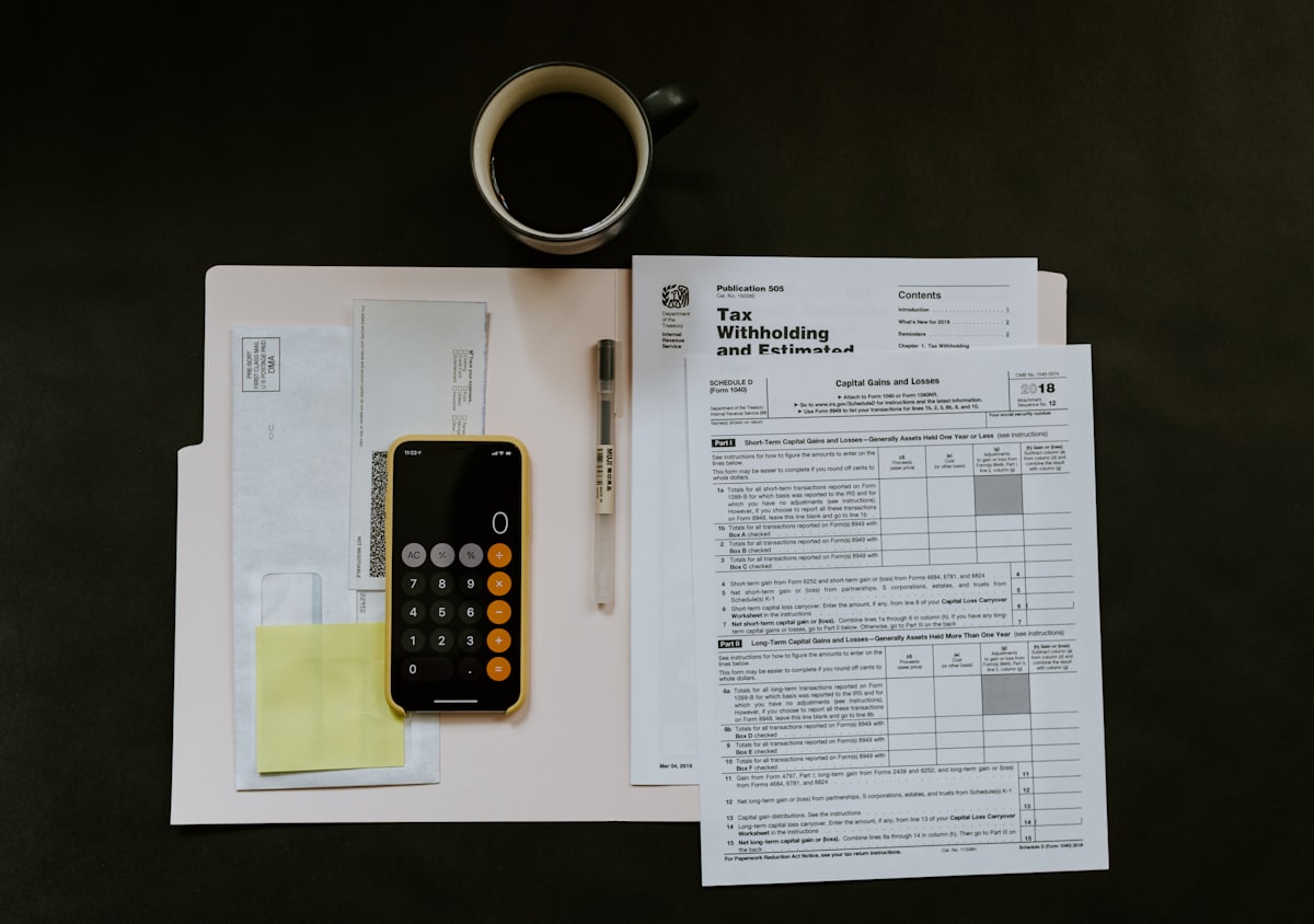 A calculator and tax forms on a desk